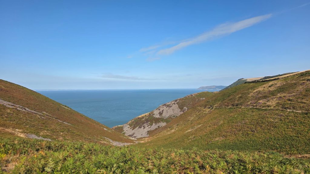 Beautiful moorland and coastal views over Countisbury Hill in Devon, overlooking the Bristol Channel on a sunny day.