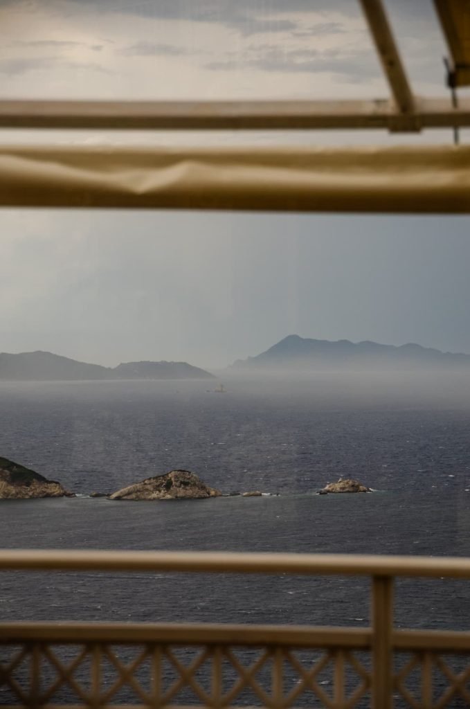 A storm rolls in over the ocean while looking out from a restaurant balcony. This photo of storm clouds provides an example of what to expect from weather conditions in Corfu in October.