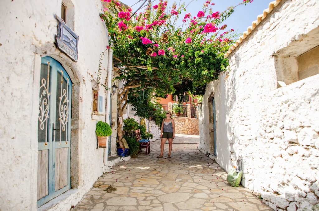 Zara stands on a rustic street in Afionas, Corfu. Exploring Corfu's villages is a great thing to do in October when weather conditions are unpredictable.