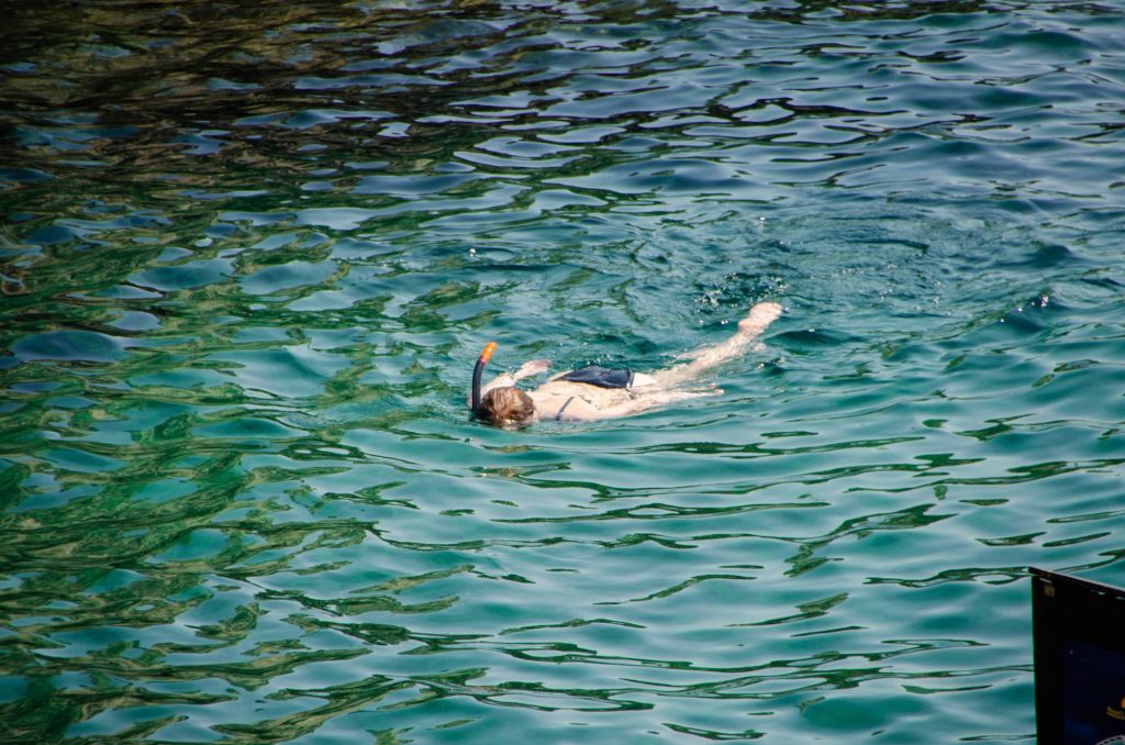Zara swimming and snorkeling in the ocean in Corfu on a sunny day.